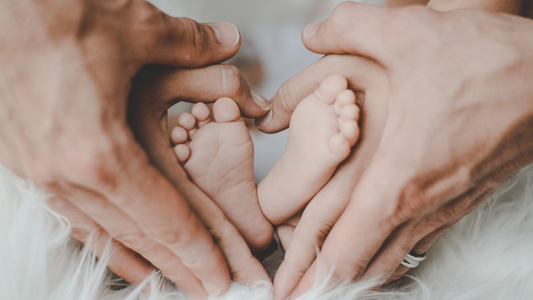 mom and dad hands holding baby feet