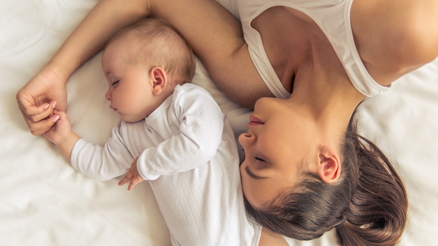 Mum sleeping next to baby in peace after completing entries in baby book
