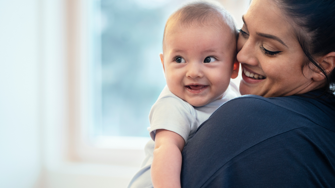 mom holding smiling baby