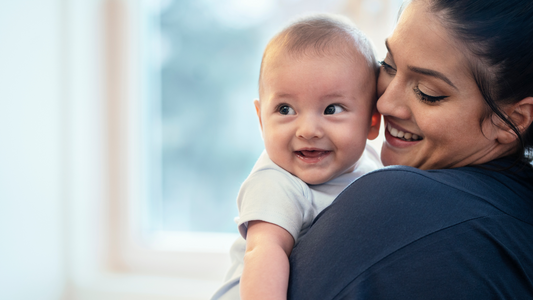 mom holding smiling baby