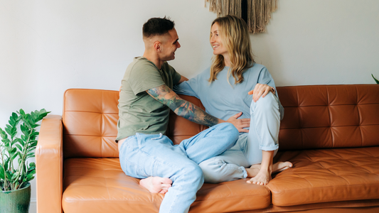 couple excited about pregnancy with partner holding wife's bump