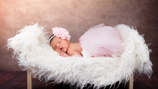 newborn baby laying on couch for photoshoot