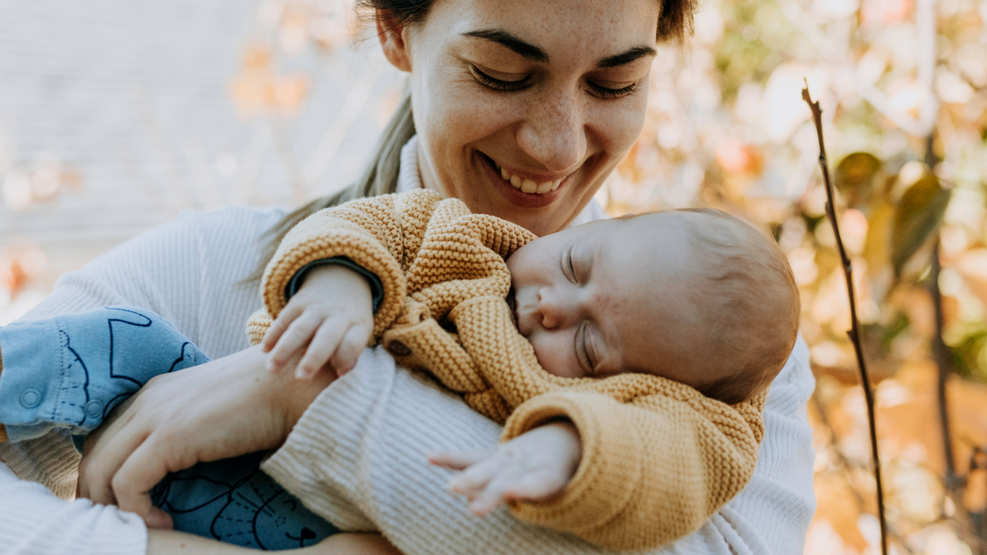 mom holding baby in autumn