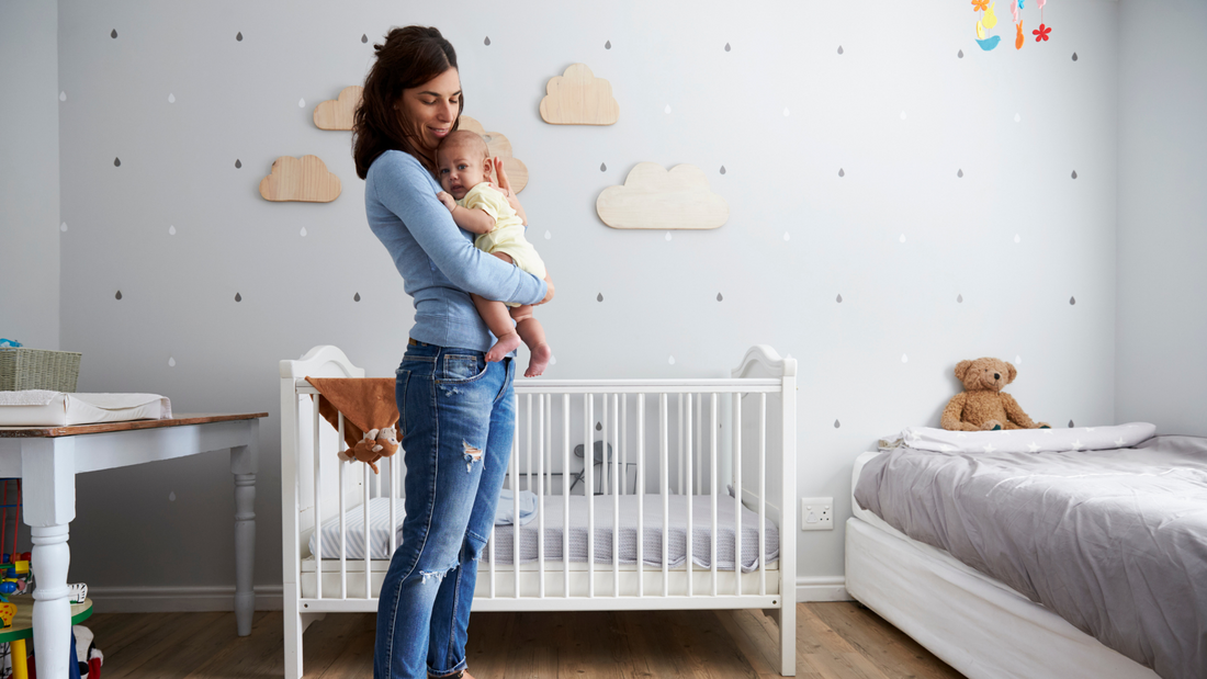 mom holding baby in nursery