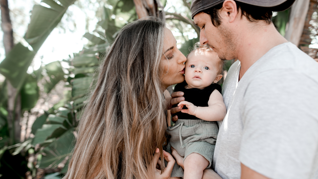parents holding baby with joy