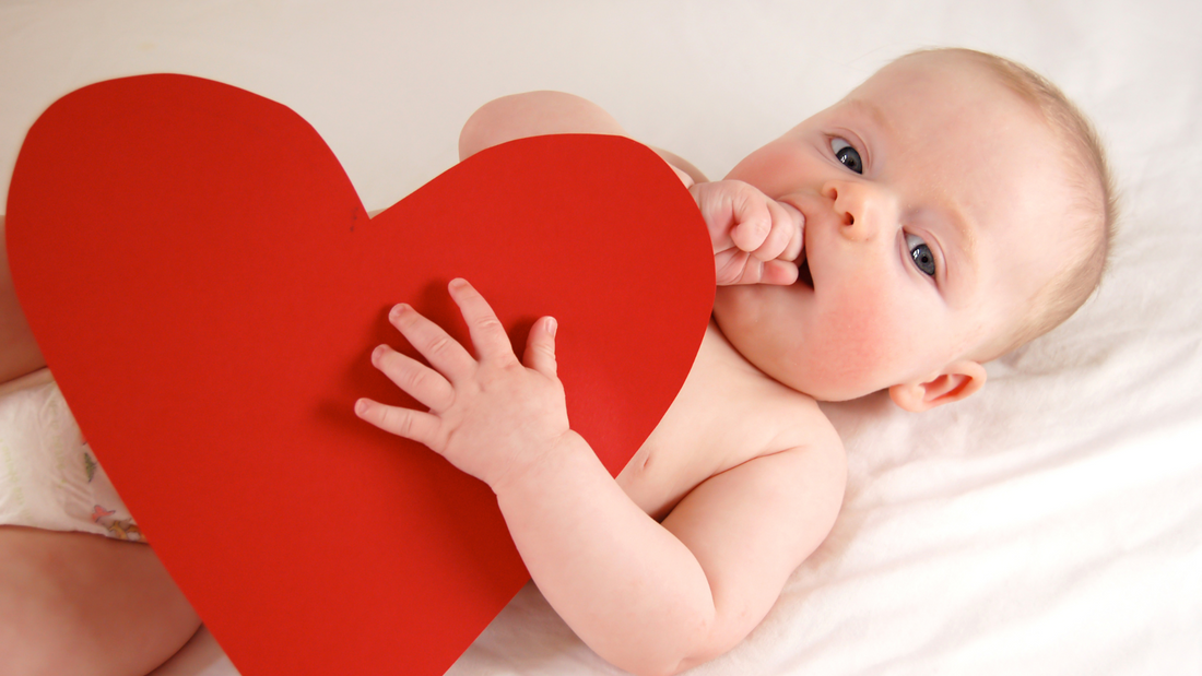 baby holding valentines day heart